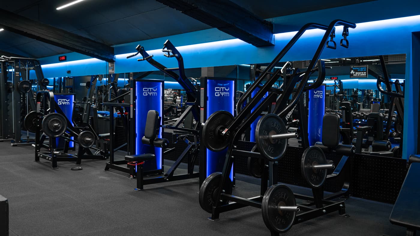 Зал CityGym: ряд тренажёров Foreman в синей подсветке